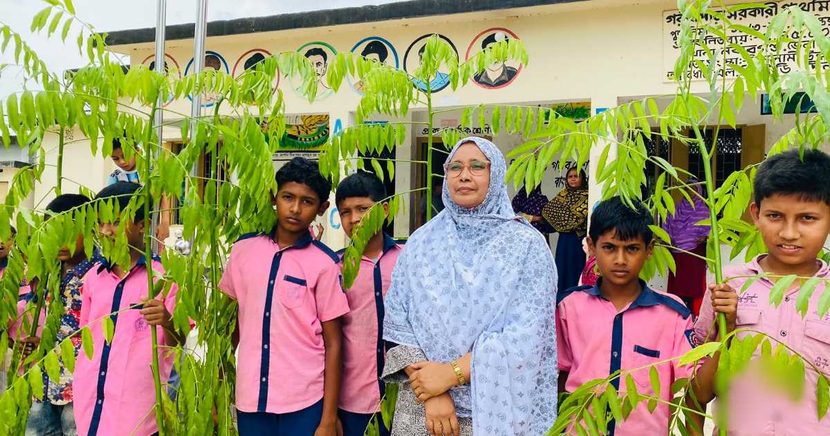 শিক্ষার্থীদের হাতে চারাগাছ তুলে দিচ্ছেন শিক্ষক